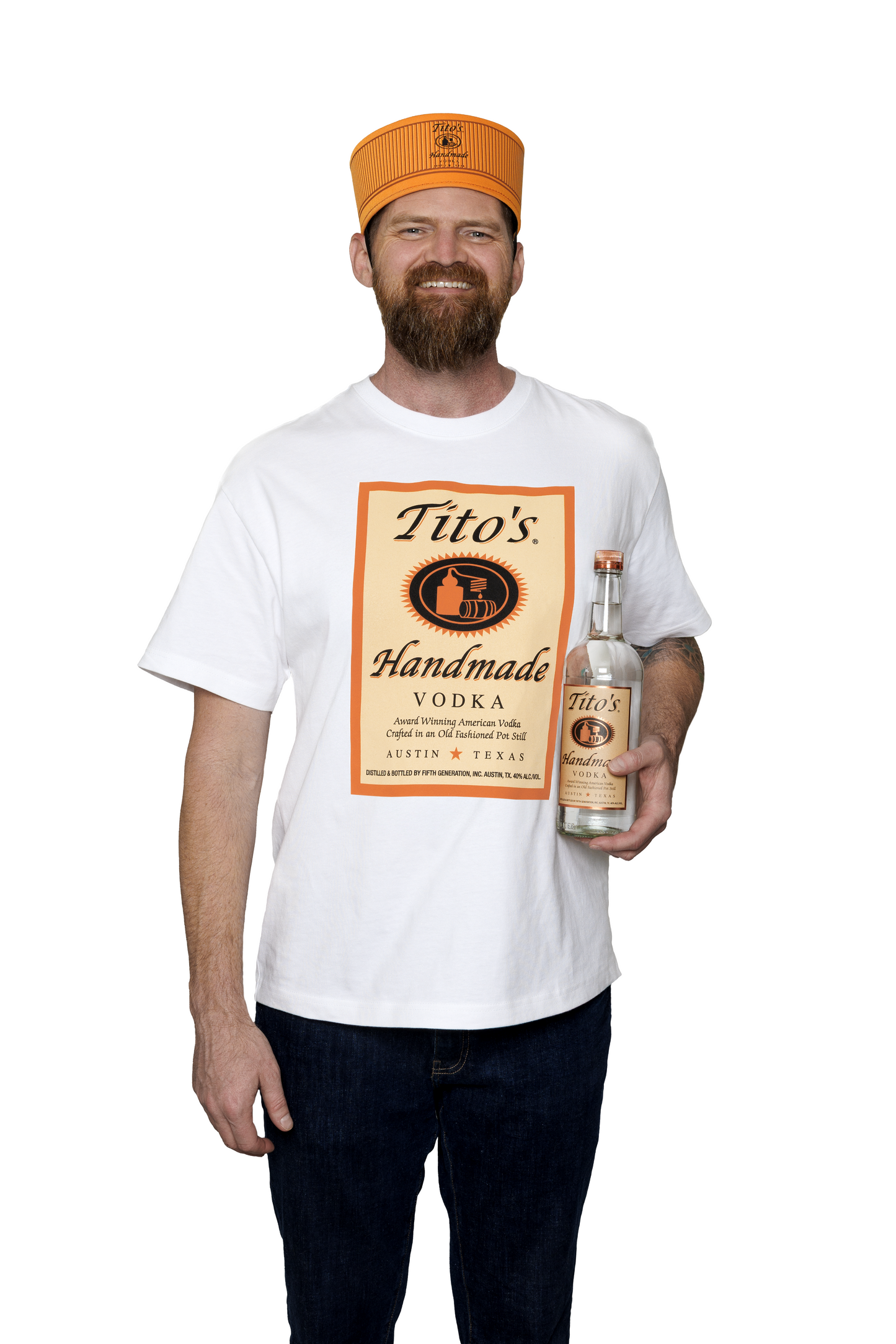 Man wearing a white t-shirt with Tito's Handmade Vodka label, a copper Tito's Bottle Cap, holding a bottle of Tito's Handmade Vodka.