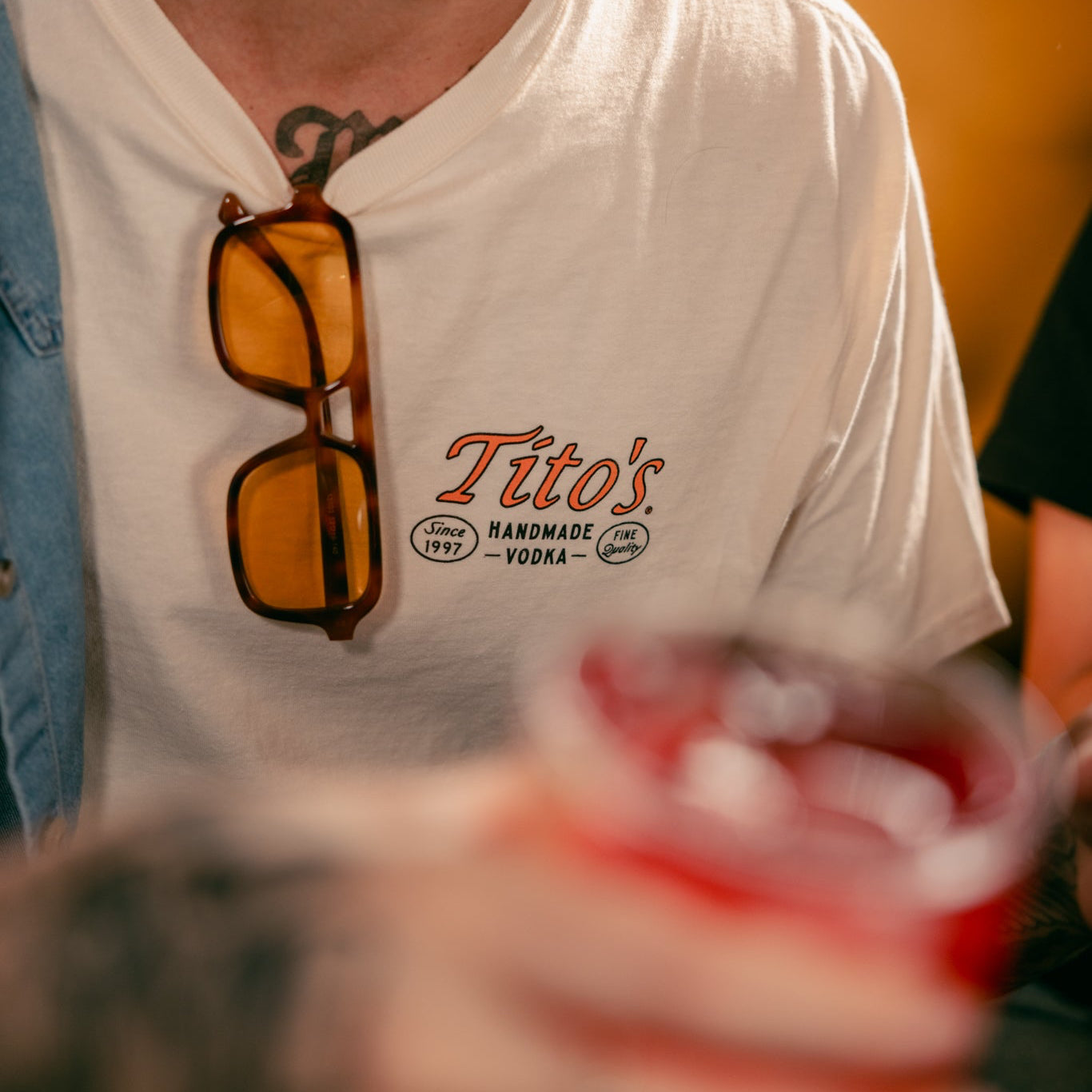 Front view of a person wearing a Tito's Lounging Armadillo Tee