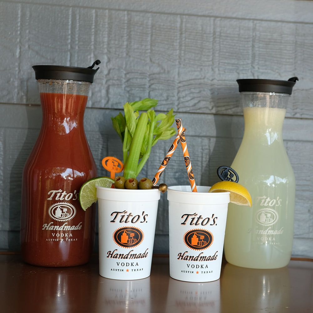 White plastic Tito's cups and carafes filled with Bloody Mary and Lemonade