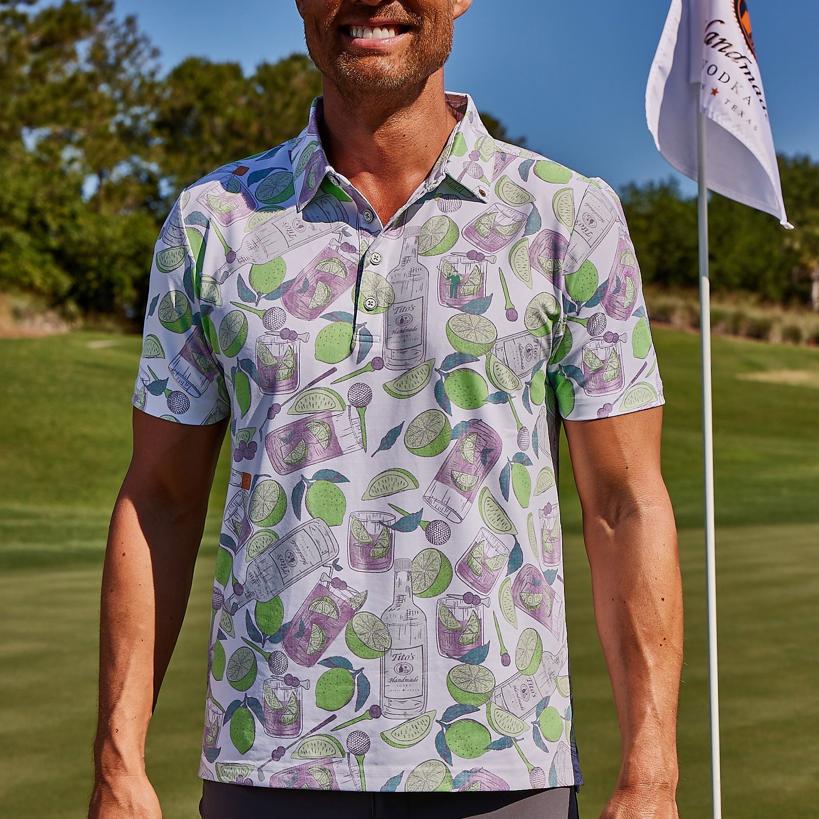 Man on golf course wearing white  Tito's X William Murray Transfusion Men's Golf Polo