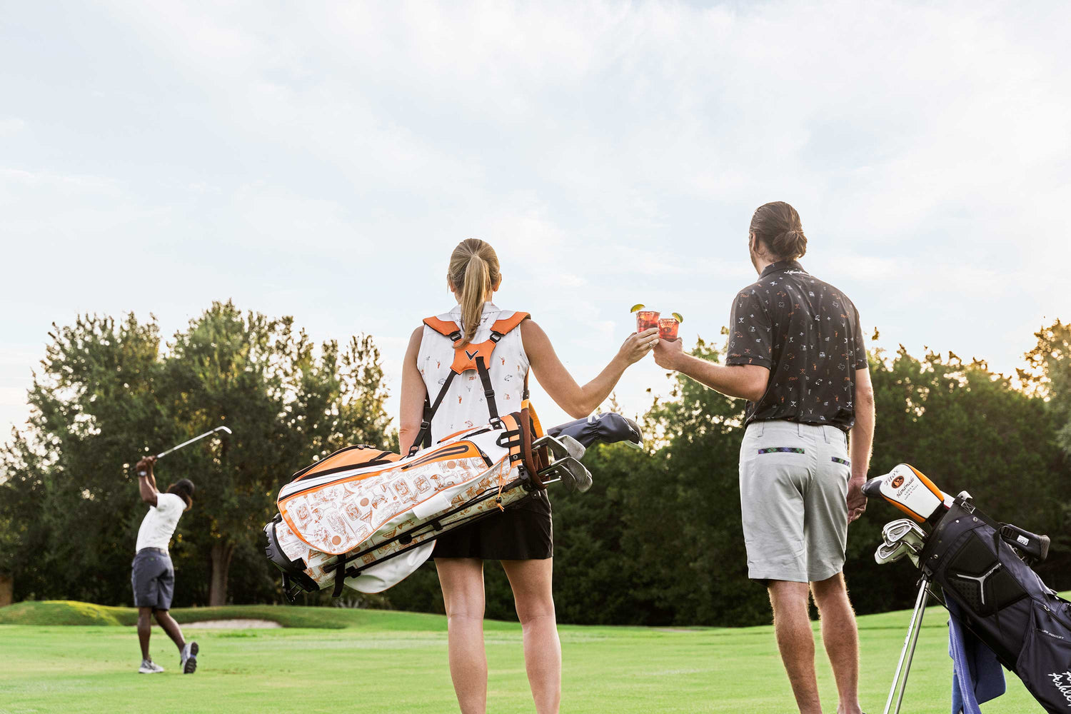 Man and woman raising a cheers on a golf course
