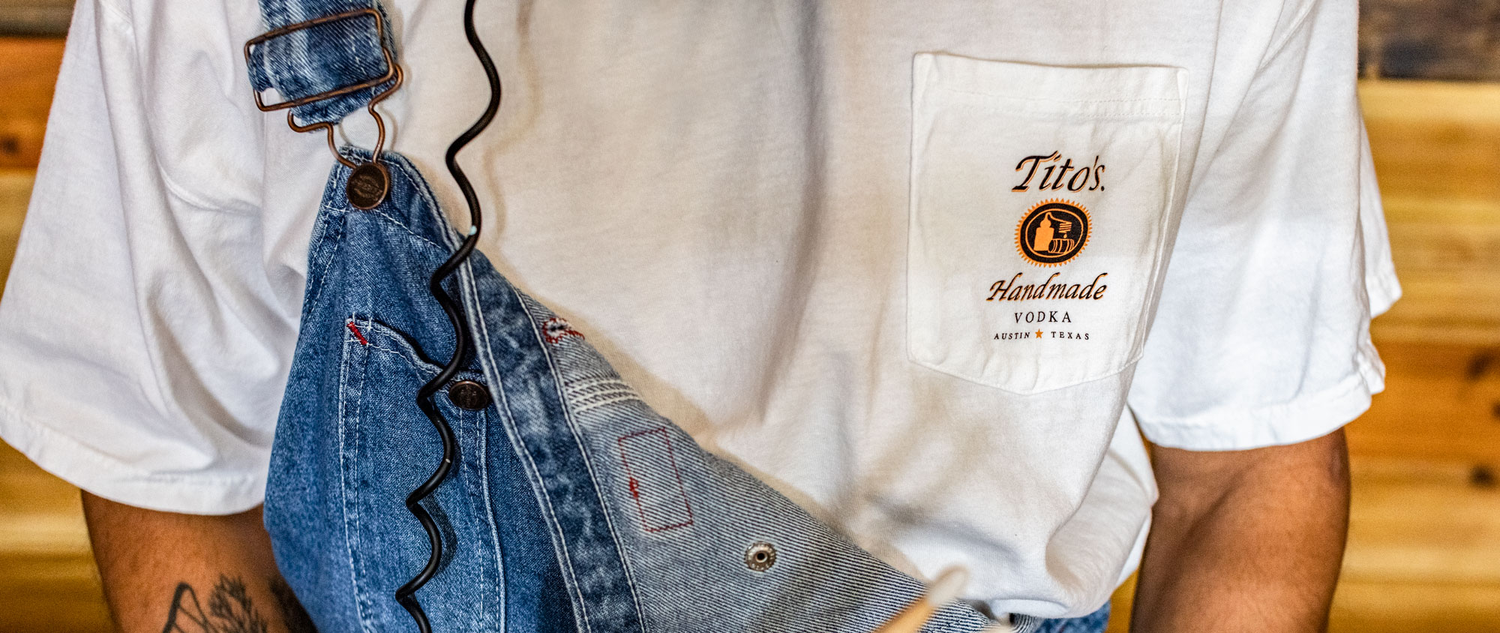 Person wearing Tito's Taster Tee and overalls
