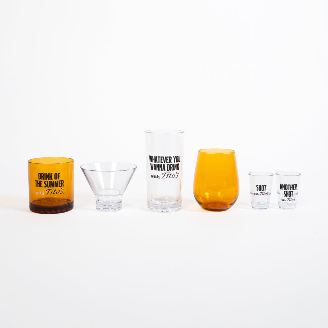 Set of clear and amber tumblers with printed text with variety of sayings on each glass