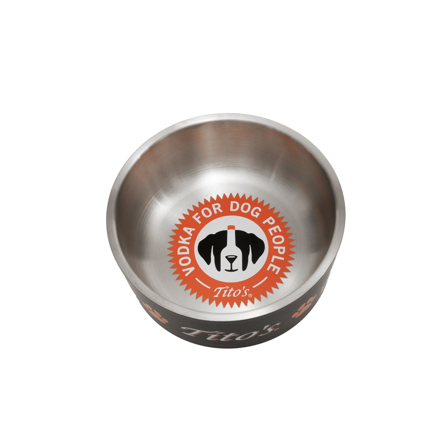 A stainless steel dog bowl with a black exterior, featuring a circular orange, white, and black logo on the inside that reads 'VODKA FOR DOG PEOPLE' and 'Tito's' . The brand name 'Tito's' is also visible on the outside of the bowl.