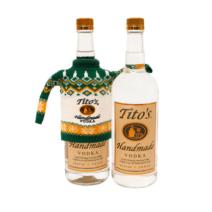 Two bottles of Tito's Handmade Vodka, one with Green and orange bottle sweater with sleeve around the other bottle without a sweater 