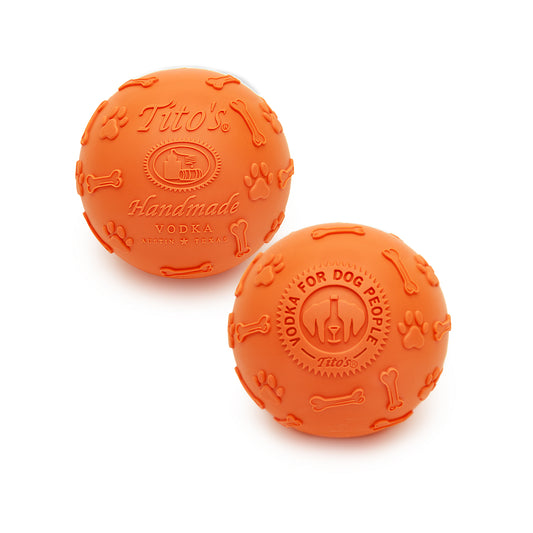 2 Orange rubber balls with Tito's Handmade Vodka logo, Vodka for Dog People logo, and paw print and dog bone designs