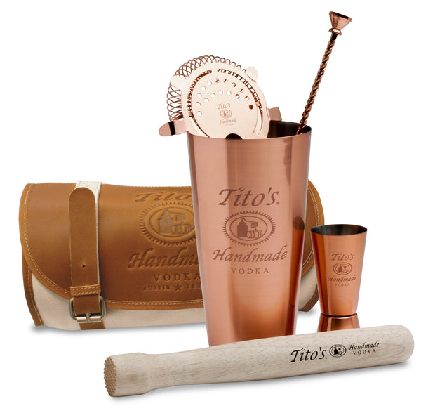 Copper mixology kit includes canvas and leather travel satchel, muddler, shaker, strainer, jigger, and bar spoon with Tito's logos