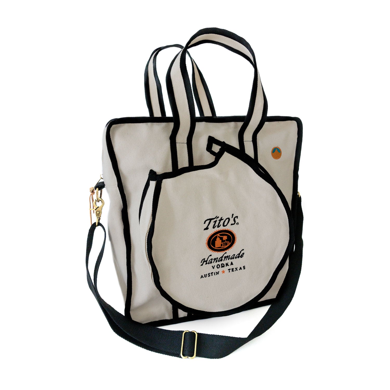 Front of cream color Tito's X Tangerine Pickleball Bag with black trim, Tito's Handmade Vodka logo, adjustable strap, and paddle pocket