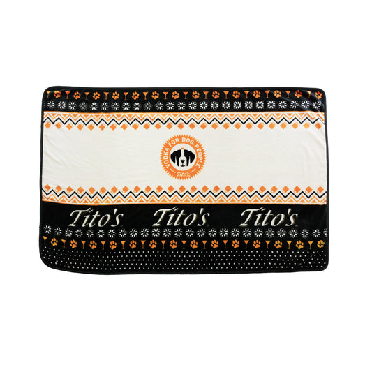 Black, orange, and white blanket with Vodka for Dog People logo, Tito's wordmark, and designs of martinis, snowflakes, and dog paws