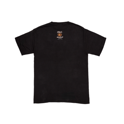Back view of a Black t-shirt with orange and white Tito's Handmade Vodka logo small in the middle of the top