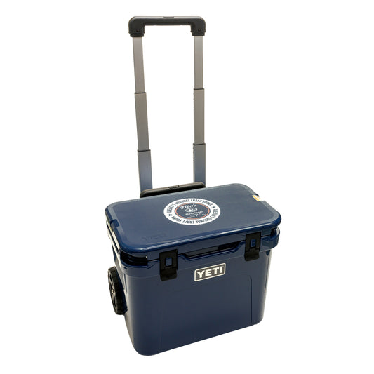 Blue YETI cooler with wheels with Tito's Handmade Vodka logo on lid