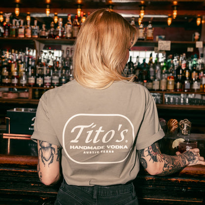 Back of person wearing a Tito's Hometown Tee in a bar setting