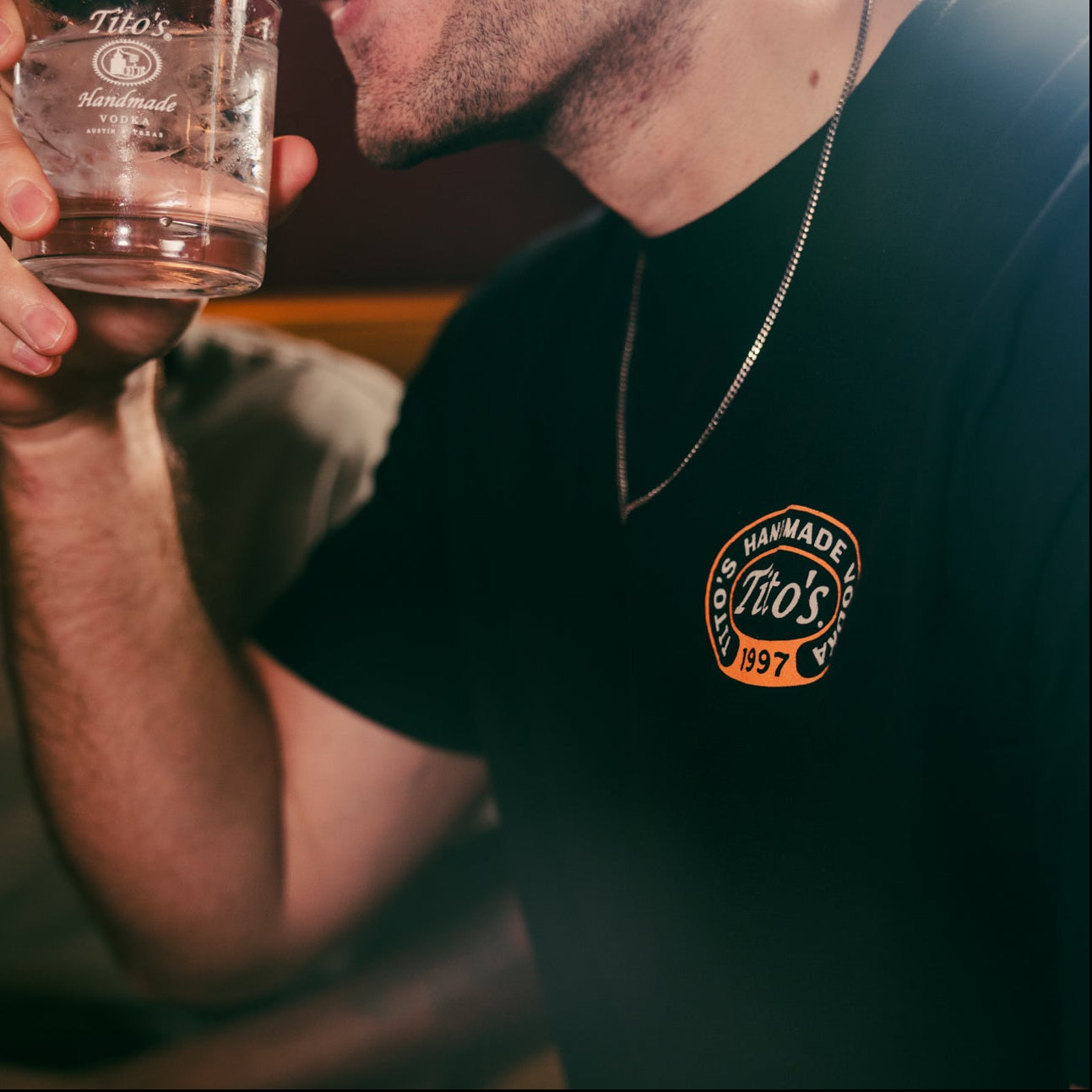 Person wearing Tito's Martini Tee and holding a Tito's cocktail 