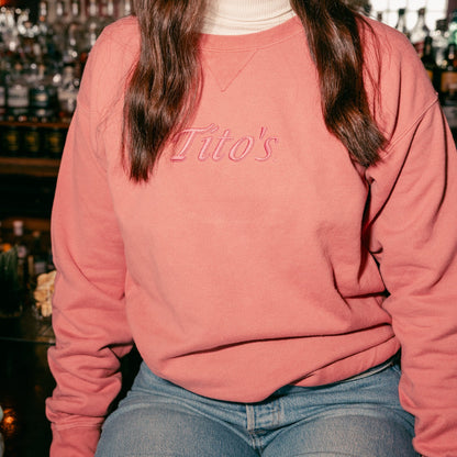 Person wearing the Rust colored Tito's Classic Crewneck sitting on a bar 