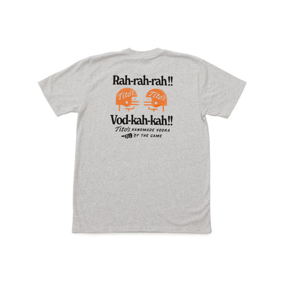 A light heather gray t-shirt shown from the back, featuring a graphic print with the text 'Rah-rah-rah!!' and 'Vod-kah-kah!!' in black, along with two orange illustrations of football helmets labeled 'Tito's'.
