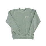 Front of sage green crewneck pullover with Tito's Handmade Vodka and Austin, Texas badge