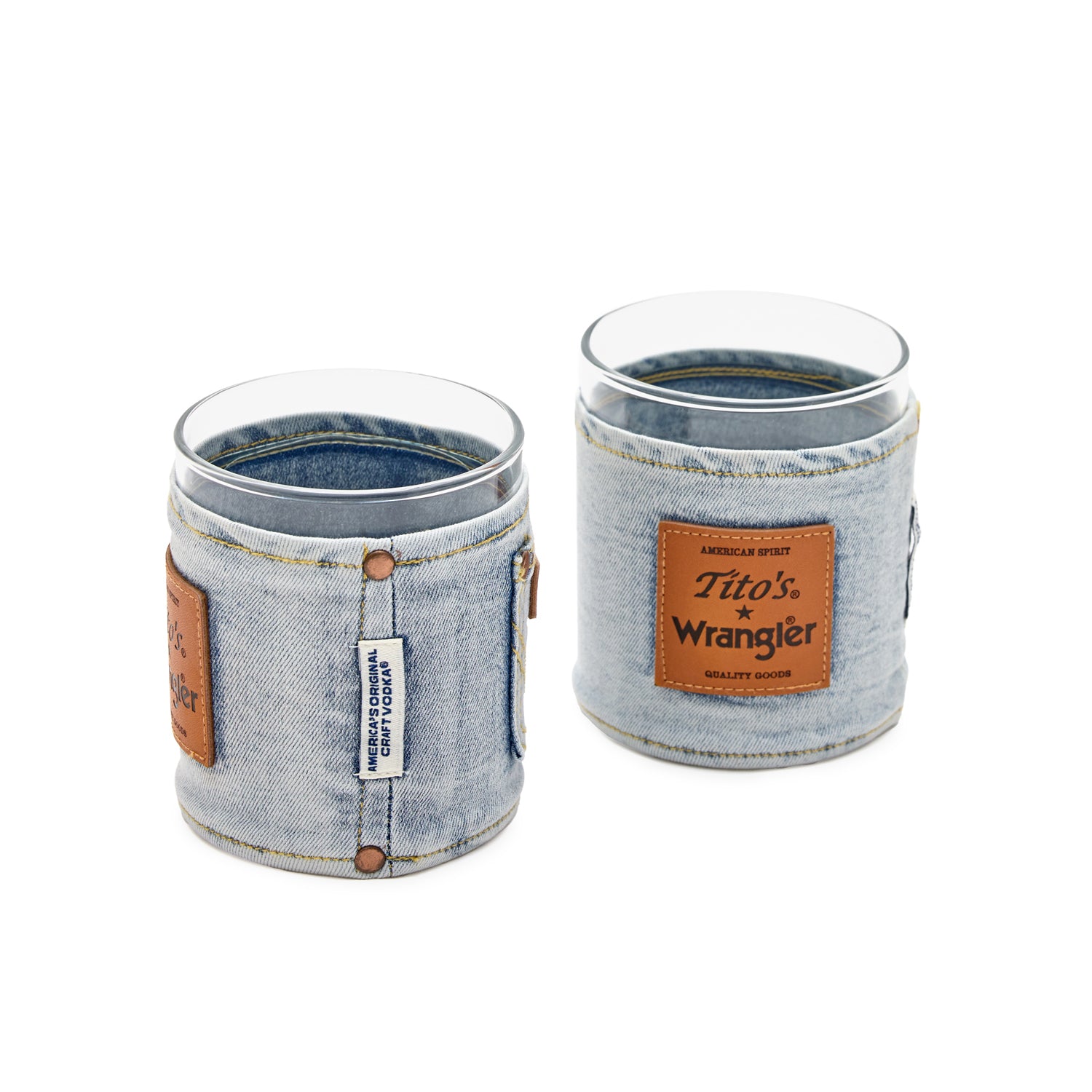 Side view and front view of 2 Wrangler rocks glass set. The side has a woven tag saying "America's Original Craft Vodka" and the front has a square leather patch with Tito's and Wrangler logos