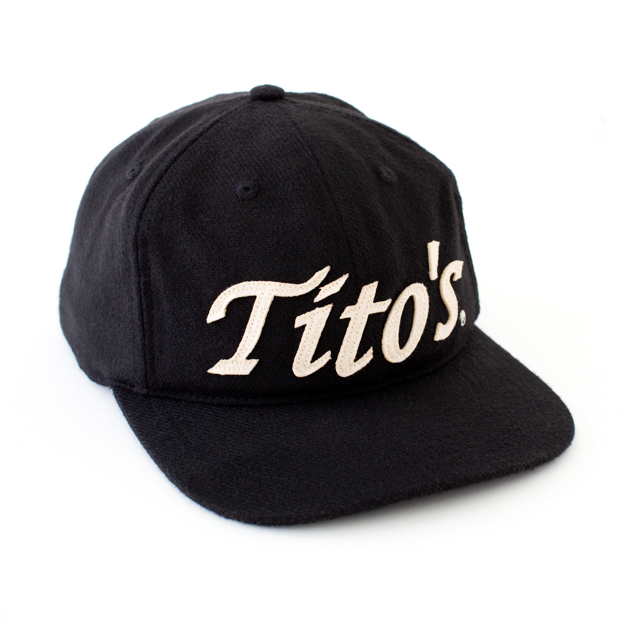 Front view of black wool hat with Tito's wordmark appliqué in creamy white felt