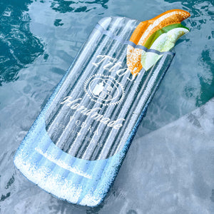 Blue pool float in a pool shaped like a cocktail with Tito's Handmade Vodka logo on the front