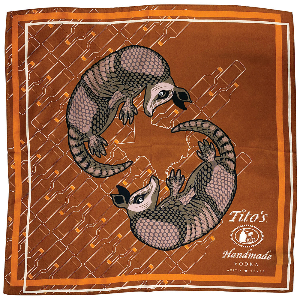 Copper silk scarf featuring white Tito's Handmade Vodka logo with illustrated armadillos and bottle designs