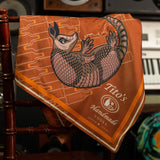Copper silk scarf featuring white Tito's Handmade Vodka logo with illustrated armadillo and bottle designs