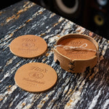 Set of leather coasters branded with Tito’s Handmade Vodka logo and coaster holder