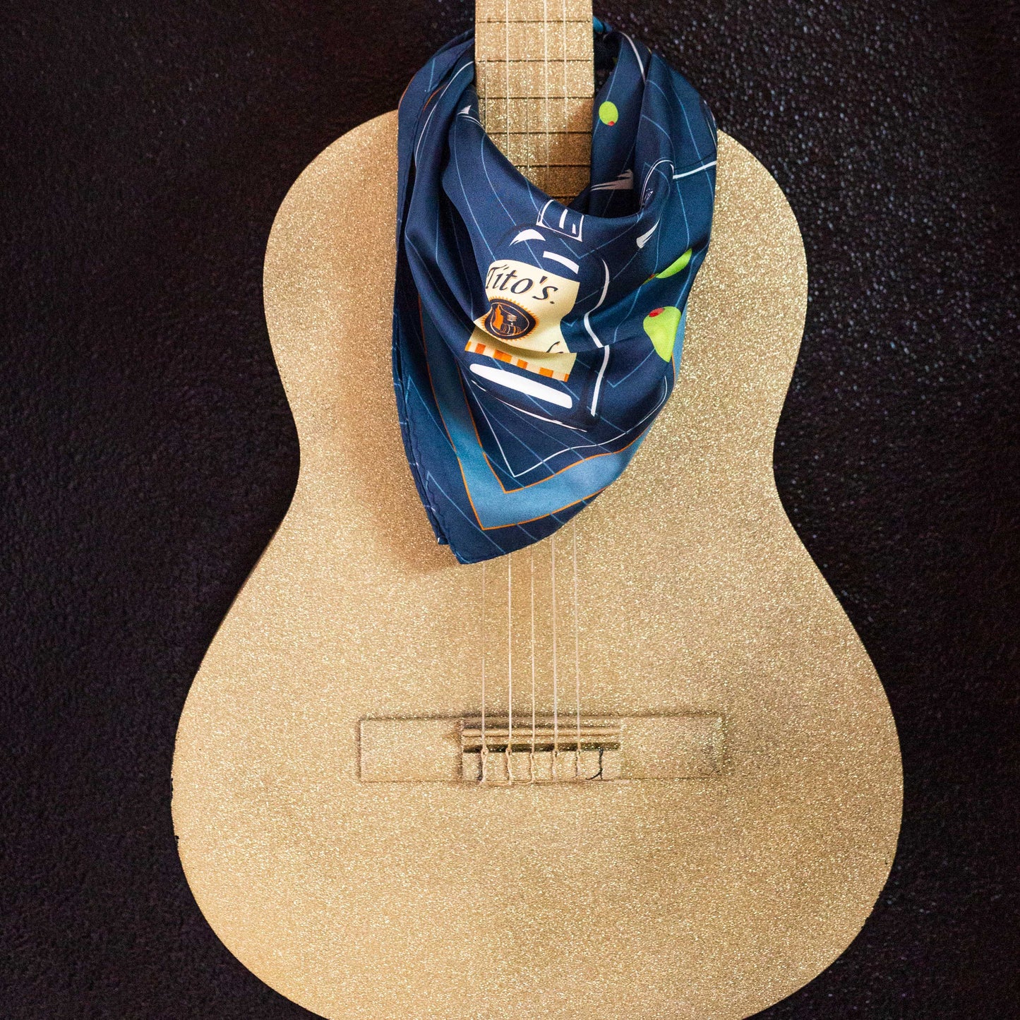 Navy Tito's Cocktail Hour Silk Scarf draped around a guitar