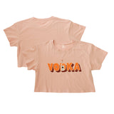 Pale pink crop top with Vodka in orange text and Tito’s Handmade Vodka bottle in the letter D on front and plain back
