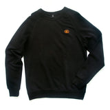 Front view of black long-sleeved pullover with embroidered orange pot still emblem on left breast