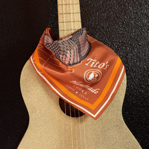 Copper Tito's Southwest Silk Scarf draped around a guitar