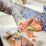 Man pouring a cocktail from a Tito's Shaker into a Tito's Copper Mug