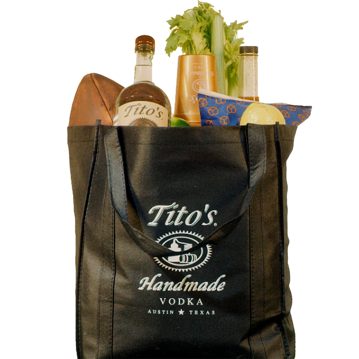 Black Tito's Tote bag filled with a Tito's Handmade Vodka bottle, football, snacks, cups and bloody mary mix