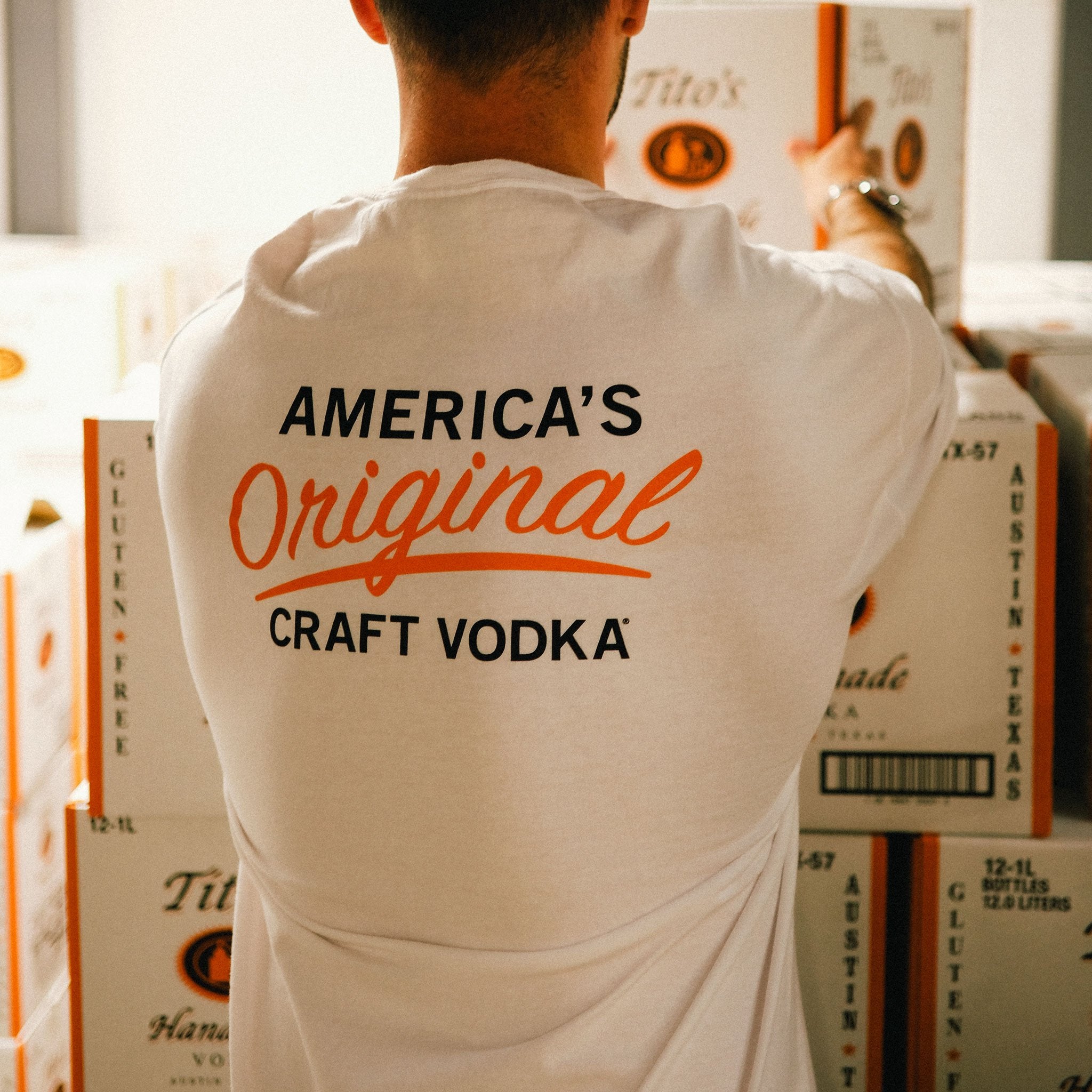 Back of person wearing short-sleeve white t-shirt with America's Original Craft Vodka mark