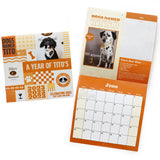 Open and closed view of orange and white desk calendar featuring dogs named Tito