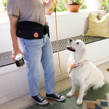 Person wearing Tito's Walk-Pack with white golden retriever on porch
