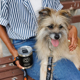 Woman sitting on bench with dog and Tito's Walk & Sip YETI Rambler® Lowball