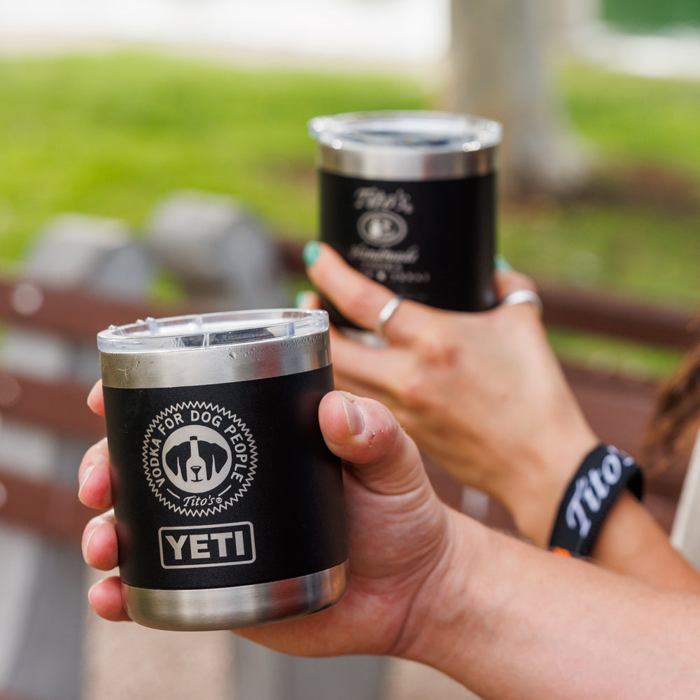 Two hands each holding a Tito's Walk & Sip YETI Rambler® Lowball