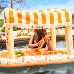 Woman making a cocktail in the pool in a Tito's X FUNBOY Floating Cabana Bar 