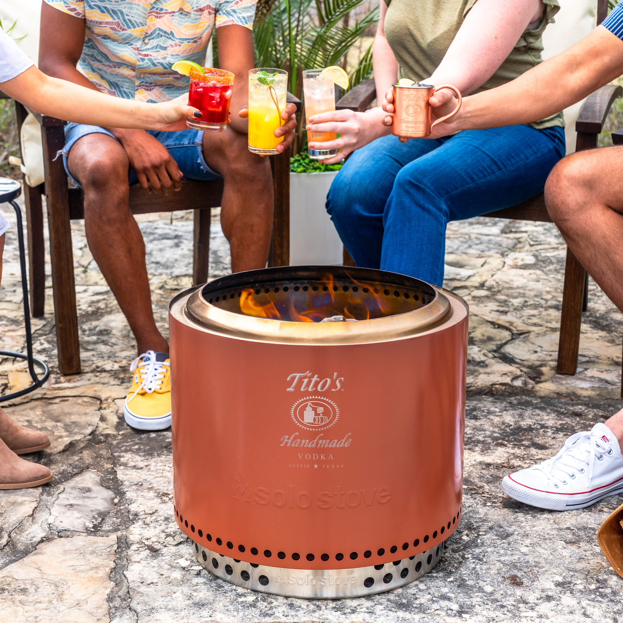 People sitting around the Tito's X Solo Stove® Original Fire Pit with cocktails