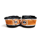 Open view of black, orange, and white collapsible dog bowl with Vodka for Dog People logo