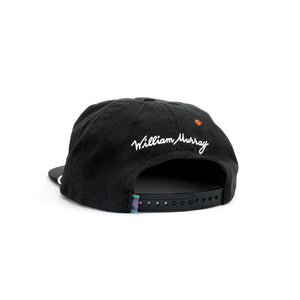 Back of black snapback with William Murray embroidered in white and adjustable snap