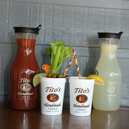 White plastic Tito's cups and carafes filled with Bloody Mary and Lemonade