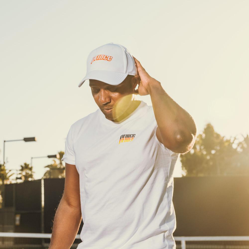 Man wearing white short sleeve tee and white prince hat