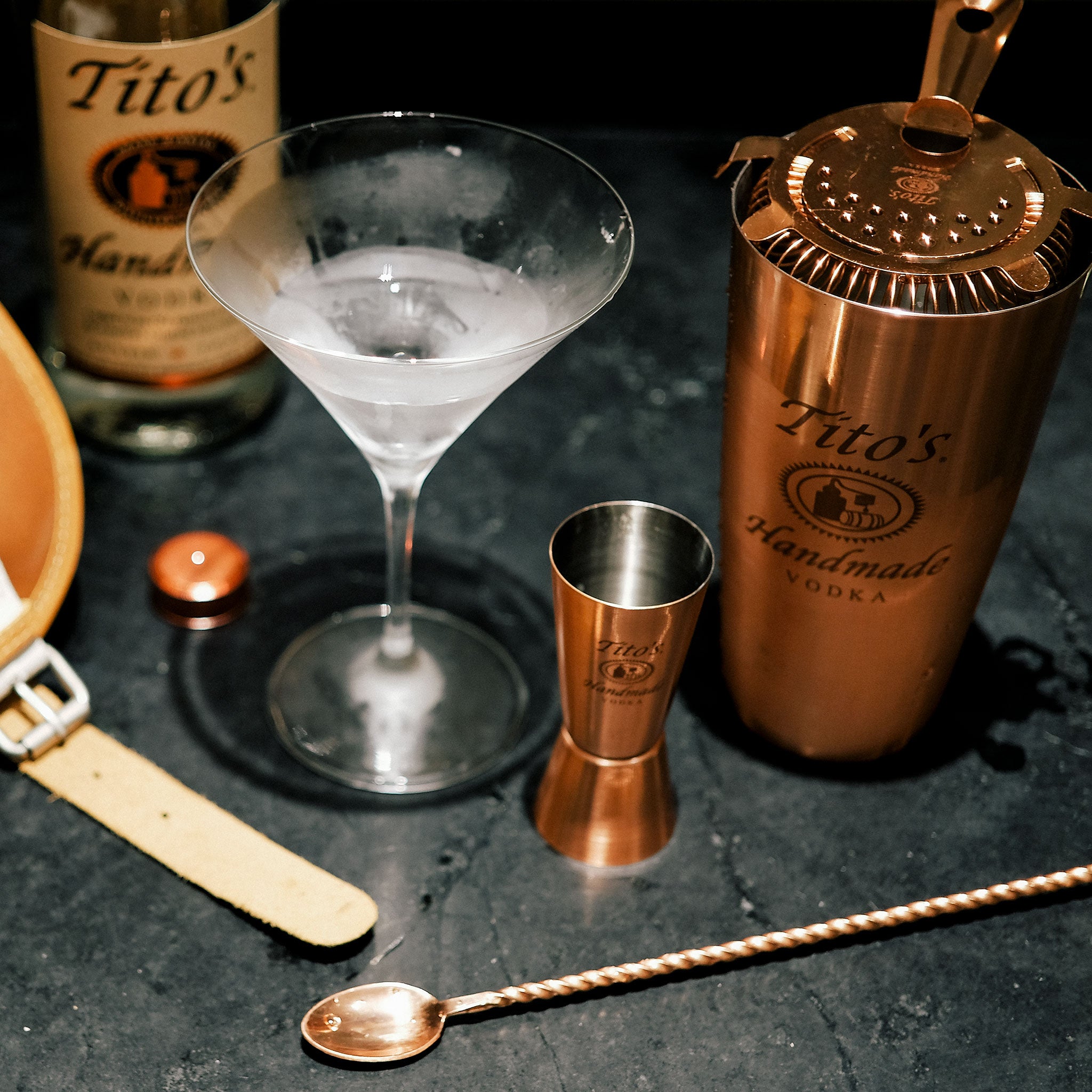 Tito's Handmade Vodka bottle with martini and copper bar tools